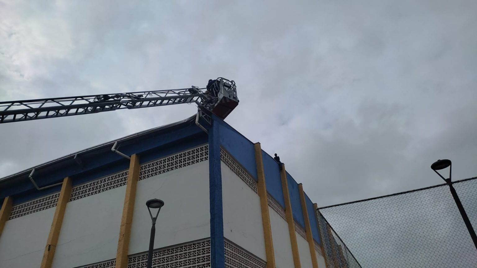 EPIs – Cobertura colapsa e instaladores de manta asfáltica ficam presos em telhado de ginásio